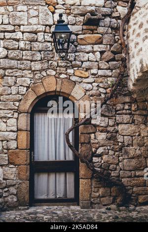 Vite arrampicata su un muro di srtone di una casa medievale del Lanas villaggio nel sud della Francia (Ardeche) Foto Stock