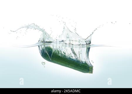 Zuchini spruzzi d'acqua. Vista laterale su sfondo bianco. Foto Stock