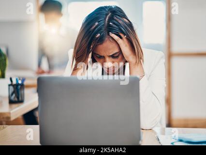 Mal di testa, stress e donna d'affari con burnout da problemi di lavoro su un notebook in ufficio. Triste, stanco e lavoratore corporativo indiano con ansia mentre Foto Stock