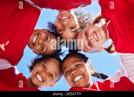 Huddle, la squadra di ragazze o gli amici nella programmazione di calcio per la strategia di calcio con il lavoro di squadra, l'obiettivo di sport o il sorriso allo stadio. Bambini felici, vista bassa o bambini Foto Stock