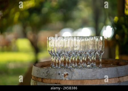 Una foto poco profonda di bicchieri da vino su un barile di vino di legno Foto Stock