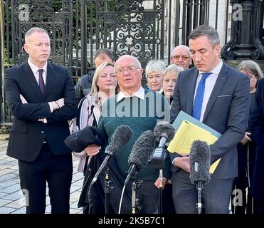 John McEvoy (al centro) con il solicitor Gavin Booth (a destra), Sinn Fein MP per il South Down Chris Hazzard (a sinistra) e sopravvissuti agli attacchi di armi lealiste al di fuori della High Court a Belfast. McEvoy, sopravvissuto ad un attacco di armi lealiste del 1992 al Thierafurth Inn di Kilcoo, Co Down, ha presentato un'impugnazione legale contro il capo del servizio di polizia dell'Irlanda del Nord. Data immagine: Venerdì 7 ottobre 2022. Foto Stock