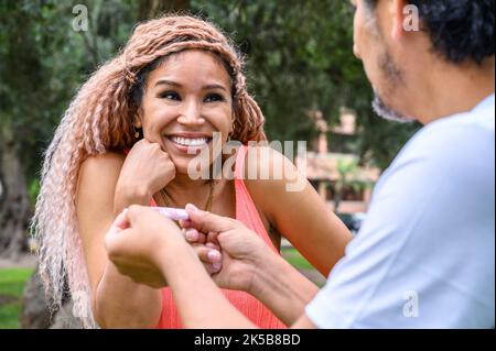 Donna uomo sorprendente con un test di gravidanza Foto Stock