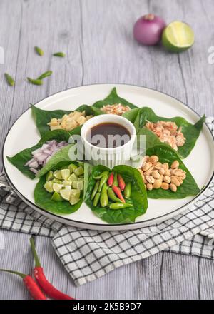 Miang kham - Un antipasto con foglie reali - e' un tradizionale spuntino del Sud Est Asiatico dalla Tailandia e dal Laos. Foto Stock