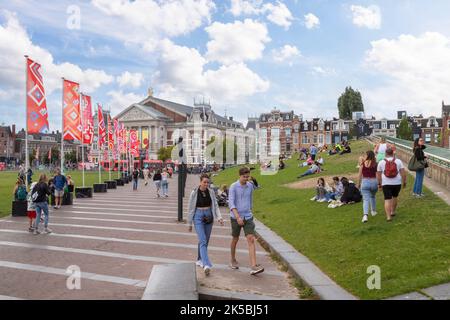 La gente del posto e i turisti possono trascorrere una giornata di sole nella piazza dei musei nella capitale olandese di Amsterdam. Foto Stock