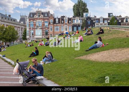 La gente del posto e i turisti possono trascorrere una giornata di sole nella piazza dei musei nella capitale olandese di Amsterdam. Foto Stock