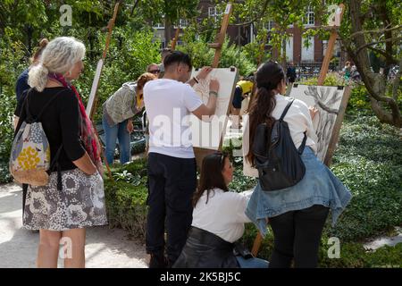 I turisti si attraggono all'aperto nei giardini del Rijksmuseum di Amsterdam. Foto Stock