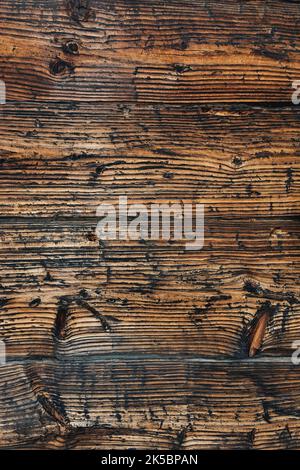 Vecchio sfondo marrone legno bruciato. Texture con un motivo naturale di linee strutturali ondulate scure. Grunge. Copia spazio per il testo. Messa a fuoco selettiva morbida. Foto verticale. Foto Stock