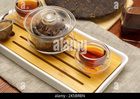 Cerimonia del tè cinese pressato pu erh tavola energia mattina in legno. Messa a fuoco selettiva Foto Stock