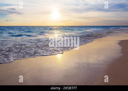 Bellissima alba sull'oceano Atlantico a Punta Cana, Repubblica Dominicana. Vivace alba all'orizzonte e mare in colori dorati. Foto Stock