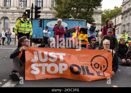 Londra, Regno Unito. 07th Ott 2022. I manifestanti hanno una bandiera che esprime la loro opinione durante il seduto in protesta di fronte a Downing Street. Il gruppo di attivisti del clima Just Stop Oil protesta il 7th° giorno di Occupy Westminster action, chiedendo di fermare tutte le future licenze e consensi per l'esplorazione, lo sviluppo e la produzione di combustibili fossili nel Regno Unito. Credit: SOPA Images Limited/Alamy Live News Foto Stock