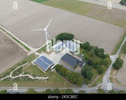 Moderna fattoria agricola con pannelli solari e turbina eolica per azienda di produzione di energia elettrica. Casa e il commercio nella produzione di cibo. Antenna Foto Stock