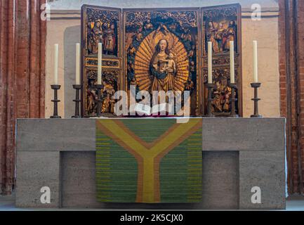 Germania, Lubecca - 13 luglio 2022: Marienkirche. Madonna o altare di Maria con reredos colorati e storici a 3 dimensioni dietro il tavolo delle celebrazioni. Foto Stock