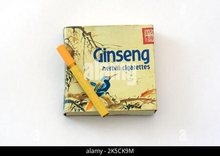 Una sigaretta di erbe ginseng gialla su una scatola con uno sfondo bianco. Foto Stock