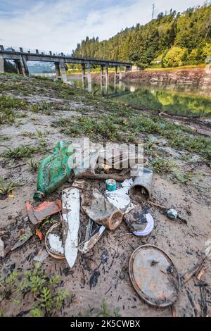 Italia, Veneto, provincia di Belluno, Lago del Centro Cadore. L'inquinamento ambientale da rifiuti e plastica è emerso con il ritiro dell'acqua dal lago Foto Stock