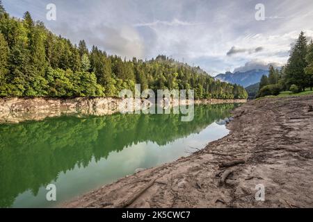 Italia, Veneto, provincia di Belluno, Domegge di Cadore. Lago del Centro Cadore, livello dell'acqua estremamente basso, le rive del lago emergono tra fango e sporcizia Foto Stock