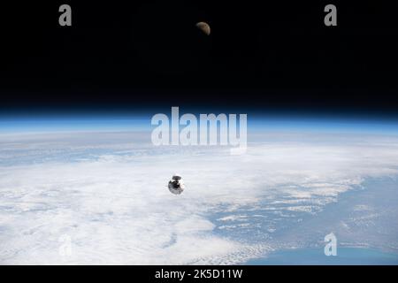La navicella spaziale Dragon Endeavour SpaceX con quattro astronauti Axiom Mission 1 si avvicina alla stazione spaziale Internazionale meno di un giorno dopo il lancio dal Kennedy Space Center, con il primo quarto di Luna visibile sopra l'orizzonte della Terra. Foto Stock