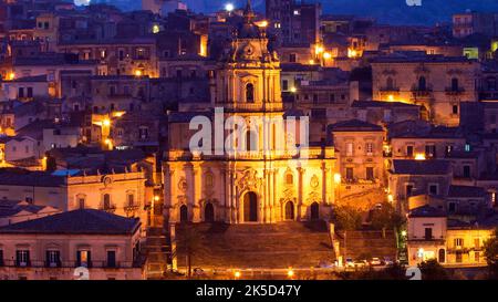 Italia, Sicilia, angolo barocco, città barocca, Modica, Centro storico, ripresa notturna, facciata Duomo San Giorgio illuminato, dietro gli edifici illuminati della città vecchia Foto Stock