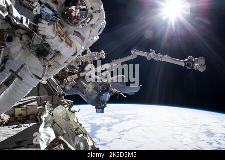 L'astronauta Raja Chari è legato alla ISS durante una passeggiata spaziale di sei ore e 54 minuti per preparare la stazione per il successivo array solare, con SpaceX Crew Dragon Endurance e Canadarm2 visibili e l'Oceano Pacifico a 262 miglia sotto. Foto Stock