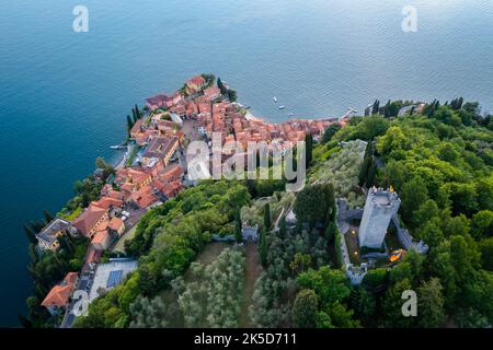 Veduta aerea del castello di Vezio, che domina il lago di Como e la città di Varenna al tramonto. Vezio, Perledo, Distretto di Lecco, Lombardia, Italia, Europa. Foto Stock