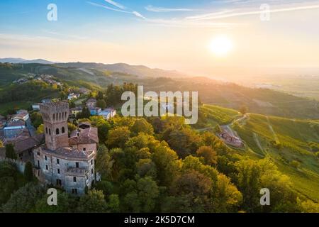 Veduta aerea del castello di Cigognola e dei vigneti al tramonto. Cigognola, Oltrepo Pavese, Provincia di Pavia, Lombardia, Italia. Foto Stock