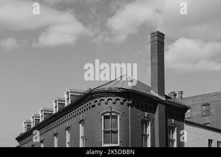 Il tetto di un edificio vittoriano in mattoni contro un cielo nuvoloso al Lowell Folk Festival nella storica Lowell, Massachusetts. L'immagine è stata catturata su b Foto Stock