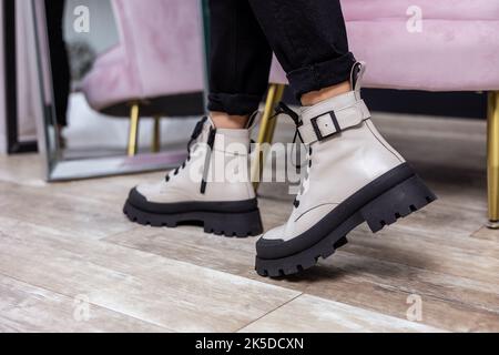 Giovane donna in beige elegante scarpe con lacci in pelle alla moda. Collezione alla moda di scarpe autunnali da donna. Primo piano delle gambe femminili nelle scarpe. Foto Stock