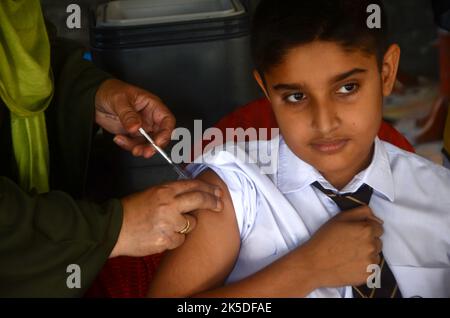 Peshawar, Pakistan. 06th Ott 2022. Uno studente riceve un vaccino contro la febbre tifoide durante una campagna di vaccinazione presso la scuola modello di Peshawar Warsak Road a Peshawar, Pakistan, il 6 ottobre 2022. Secondo il reparto sanitario, tutti i bambini di età compresa tra 9 mesi e 15 anni saranno vaccinati nella prima fase della campagna. (Foto di Hussain Ali/Pacific Press/Sipa USA) Credit: Sipa USA/Alamy Live News Foto Stock