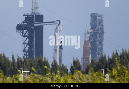 Il razzo Space Launch System (SLS) della NASA con la navicella spaziale Orion a bordo è visto in cima a un lanciatore mobile al Launch Complex 39B, a destra, Come un razzo SpaceX Falcon 9 con la navicella spaziale Crew Dragon della compagnia a bordo è visto sul piazzale di lancio al Launch Complex 39A mentre i preparativi per la missione Crew-4, venerdì 22 aprile 2022, al Kennedy Space Center della NASA in Florida. La missione SpaceX Crew-4 della NASA è la quarta missione di rotazione dell'equipaggio della navicella spaziale SpaceX Crew Dragon e del razzo Falcon 9 verso la Stazione spaziale Internazionale come parte del Commercial Crew Program dell'agenzia. Astronauti della NASA kJ Foto Stock