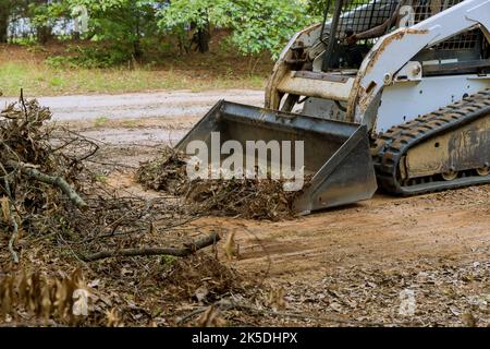 Durante i lavori di architettura paesaggistica, il bulldozer viene utilizzato per spostare la terra con la paletta ad esso collegata Foto Stock