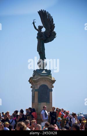 Brighton & Hove Pride Festival, Brighton & Hove, East Sussex, Inghilterra. La statua della Pace sul confine di Brighton e Hove circondata da una folla di persone. Foto Stock