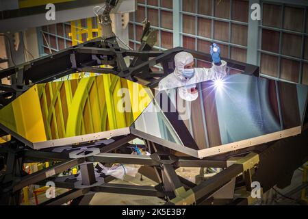 Preparazione del James Webb Space Telescope (JWST), l'ingegnere ottico Larkin Carey esamina due segmenti di specchio di prova recentemente collocati su una struttura composita nera. Questa struttura composita nera è chiamata 'Pathfinder' di JWST e funge da colonna vertebrale che supporta i segmenti di specchio principali del telescopio. Gli specchi sono stati installati utilizzando un braccio robotico che ha coinvolto ingegneri e tecnici altamente qualificati di Exelis, Northrop Grumman e NASA. Una versione ottimizzata di un'immagine NASA di Chris Gunn, un fotografo esperto. Credito: NASA/Chris Gunn. Solo per uso editoriale. Foto Stock