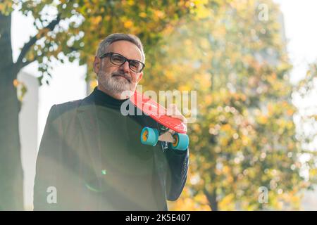 Uomo anziano barbuto in occhiali da sole rave al neon incandescente  guardando lontano su sfondo rosa Foto stock - Alamy