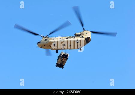 US Army Boeing CH-47 Chinook assegnato al 1st Battaglione, 111th Aviation Regiment, trasporta un veicolo a ruote multiuso ad alta mobilità (HMMWV) assegnato al 1st Squadron, 153rd Cavallry Regiment a Lee County Florida durante gli sforzi di risposta di emergenza dall'uragano Ian a Pine Island Florida 3, ottobre 2022. I soldati assegnati allo Squadrone del 1st, 153rd reggimento di cavalleria utilizzarono questi veicoli per attraversare vari terreni dell'isola dopo la distruzione dell'uragano Ian. (Foto della Guardia Nazionale dell'Esercito della Florida del personale Sgt. Cassandra Vieira) Foto Stock