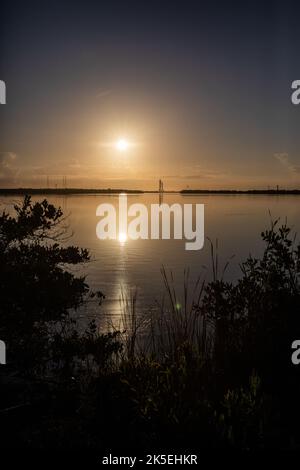 Mentre il Sole sorge luminoso nel cielo, il razzo Artemis i Moon della NASA – portato in cima al cingolato-trasportatore 2 – può essere visto da lontano mentre si avvicina al complesso di lancio 39B al Kennedy Space Center della NASA in Florida il 6 giugno 2022. Il razzo è uscito dal Vehicle Assembly Building nelle prime ore del mattino per percorrere le 4,2 miglia fino al piazzale di lancio per il prossimo tentativo di prova di abbigliamento bagnato della NASA prima del lancio di Artemis I. La prima di una serie di missioni sempre più complesse, Artemis i testerà il razzo Space Launch System e la navicella spaziale Orion come sistema integrato prima dei voli con equipaggio Foto Stock