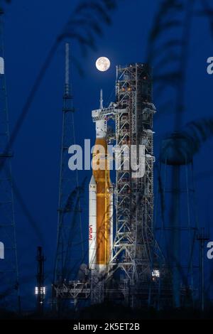 Una Luna piena è in vista dal Launch Complex 39B al Kennedy Space Center della NASA in Florida il 14 giugno 2022. Il sistema spaziale Artemis i Space Launch System (SLS) e la navicella spaziale Orion, in cima al lanciatore mobile, sono in preparazione per una prova di vestito bagnato per praticare le tempistiche e le procedure per il lancio. La prima di una serie sempre più complessa di missioni, Artemis i testerà SLS e Orion come sistema integrato prima dei voli con equipaggio per la Luna. Attraverso Artemis, la NASA atterrà la prima donna e la prima persona di colore sulla superficie lunare, spianando la strada ad una presenza lunare a lungo termine e utilizzando il Moo Foto Stock