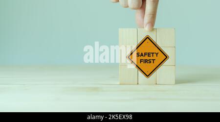 Simboli Safety First, sicurezza sul lavoro, attenzione rischi sul lavoro, sorveglianza del pericolo, concetto di zero incidenti. Cubi di legno con elegante sfondo grigio. Dipendente Foto Stock