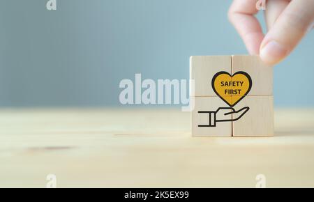 Simboli Safety First, sicurezza sul lavoro, attenzione rischi sul lavoro, sorveglianza del pericolo, concetto di zero incidenti. Cubi di legno con elegante sfondo grigio. Dipendente Foto Stock