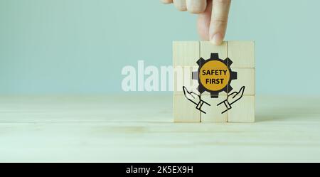 Simboli Safety First, sicurezza sul lavoro, attenzione rischi sul lavoro, sorveglianza del pericolo, concetto di zero incidenti. Cubi di legno con elegante sfondo grigio. Dipendente Foto Stock