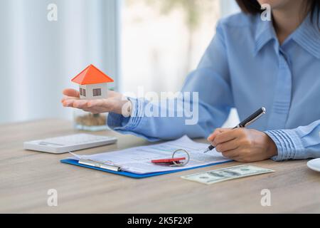 Gli agenti immobiliari offrono listini prezzi e condizioni per l'acquisto di case, case commerciali e immobili. Foto Stock