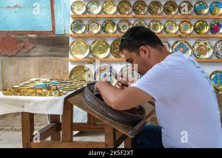 BUKHARA, UZBEKISTAN - 10 SETTEMBRE 2022: Maestro di opere artistiche di conio Foto Stock