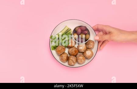 Polpette greche keftedes su sfondo a colori. Cibo tradizionale. Concetto di fotografia creativa. Vista dall'alto, spazio di copia Foto Stock