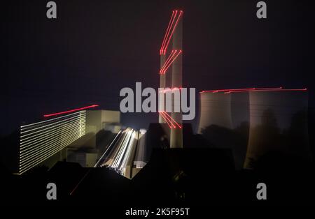 Lahde, Germania. 08th Ott 2022. Le luci della centrale elettrica di Heyden sono visibili attraverso la nebbia leggera. La centrale a carbone è stata tolta dalla riserva per ridurre il consumo di gas naturale nella produzione di elettricità. (Shot with zoom effect) Credit: Lino Mirgeler/dpa/Alamy Live News Foto Stock