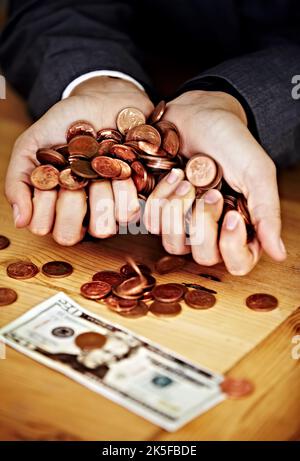 Ogni centesimo conta. Colpo di primo piano di mani che tengono monete con una banconota sul tavolo. Foto Stock
