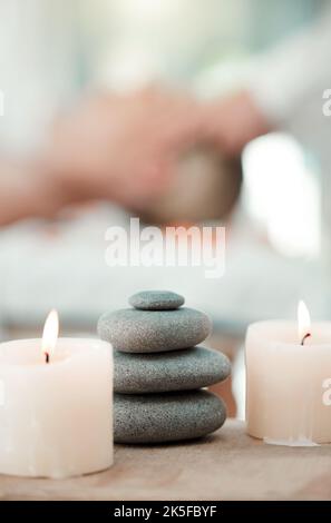 Spa, rock e candela per rilassarsi in una sala con atmosfera, umore o ambiente in un centro benessere. Benessere, lusso e trattamento con oggetti di natura morta Foto Stock