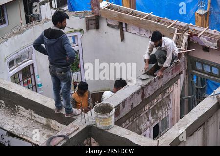 22 Giugno 2022, Darjeeling, India, lavoratore di costruzione indefinito che costruisce o costruisce il muro mettendo mattoni e cemento in darjeeling, India - conce Foto Stock