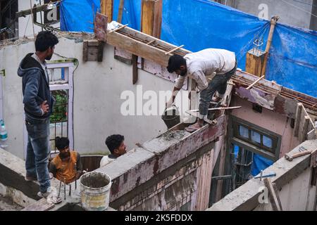 22 Giugno 2022, Darjeeling, India, lavoratore di costruzione indefinito che costruisce o costruisce il muro mettendo mattoni e cemento in darjeeling, India - conce Foto Stock