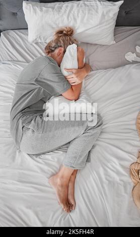 Triste, depressione e donna con insonnia dopo il divorzio nel letto in casa dall'alto. Vista dall'alto di una ragazza depressa, stanca e malata con stress, burnout Foto Stock