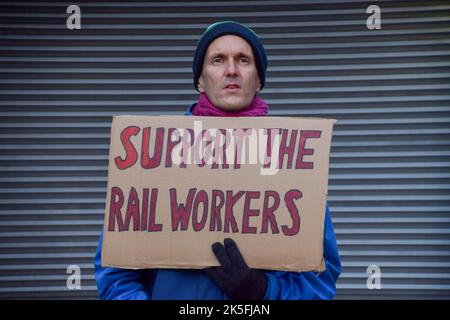 Londra, Inghilterra, Regno Unito. 8th Ott 2022. Un uomo tiene un cartello a sostegno dei lavoratori ferroviari al picket fuori dalla stazione di Euston mentre i lavoratori ferroviari palcoscenico ulteriori camminamenti oltre la retribuzione. Credit: ZUMA Press, Inc./Alamy Live News Foto Stock