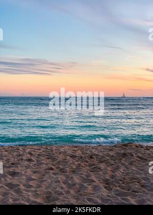 Un suggestivo scatto verticale di un tramonto ipnotico e morbido sulla tranquilla spiaggia Foto Stock